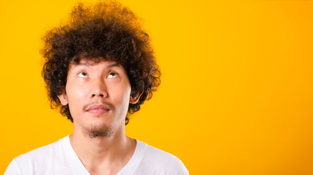 Asian handsome man with curly hair looking up see he hair isolat