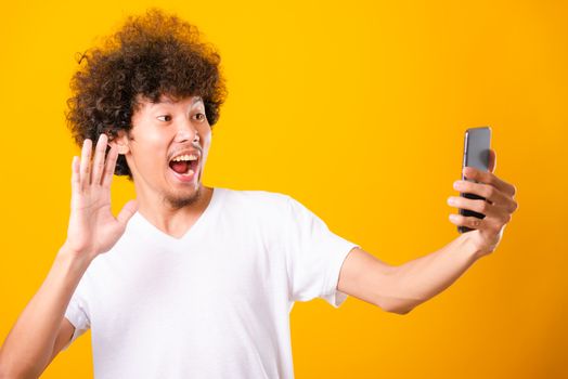 Portrait asian handsome man curly hair taking selfie with mobile