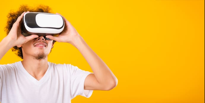 Asian handsome man with curly hair he using virtual reality head