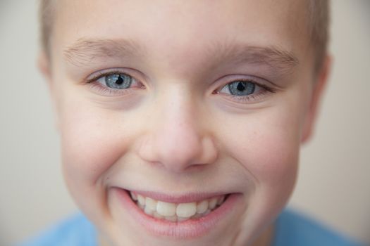 close up of a young boy giving a toothy smile at the camera