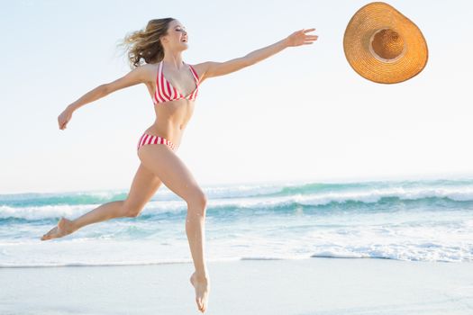 Elegant young woman jumping on beach