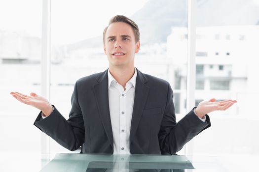 Displeased businessman with hand gesture at office desk