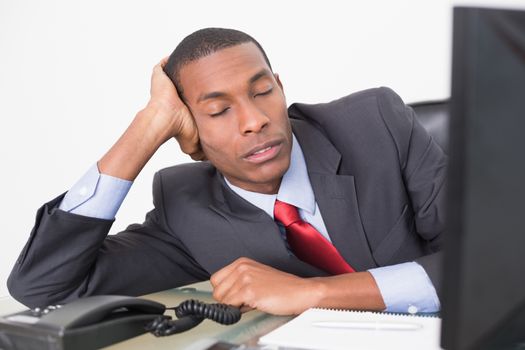 Young Afro businessman resting at desk