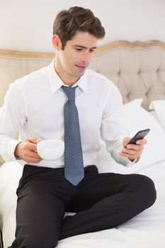 Well dressed man text messaging in bed