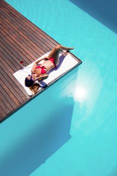 Woman enjoying sunbath on the pool edge