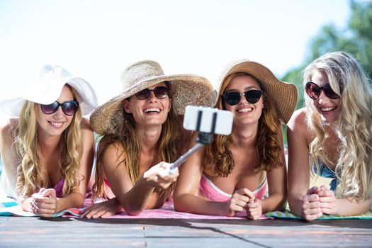 Group of friends taking selfie with selfie stick