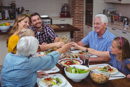 Multi generation family toasting white wine while celebrating thanksgiving 