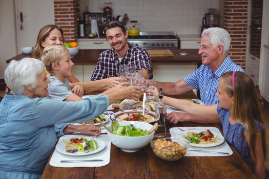 Multi generation family toasting drink while celebrating thanksgiving