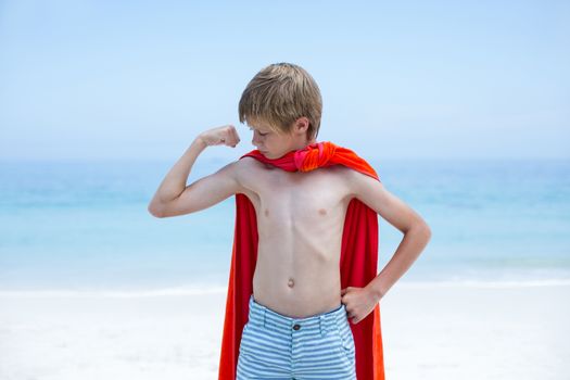 Boy in superhero costume flexing muscles 