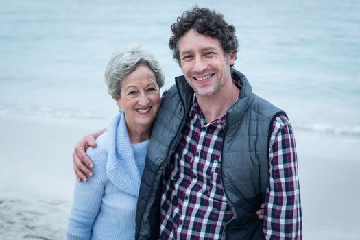 Happy mid adult man with mother at sea shore