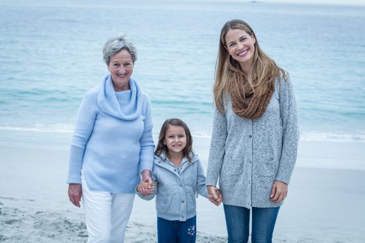 Three generations of women standing at beach