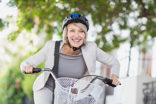 Cheerful businesswoman cycling