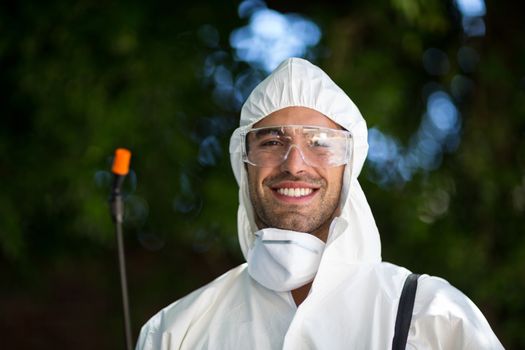 Close-up portrait of smiling man with pesticide sprayer 