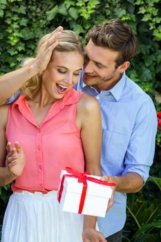 Romantic man giving gift to woman at front yard