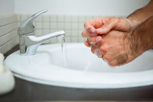 Man washing hands in washbasin