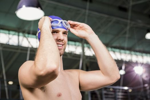 Happy swimmer wearing swimming goggles and cap