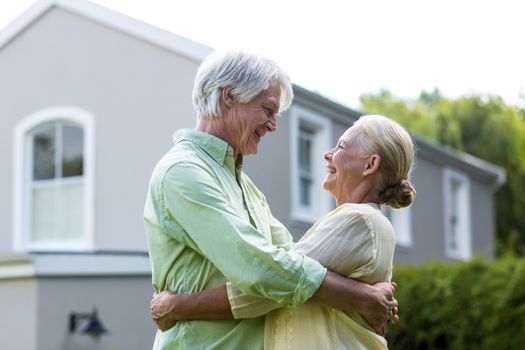 Smiling senior couple embracing in yard