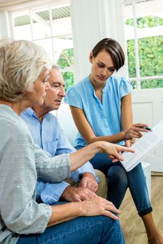 Female consultant reading report with senior couple