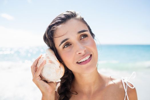  Portrait of smiling woman listening shellfish 