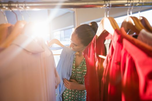  Woman selecting an apparel while shopping for clothes
