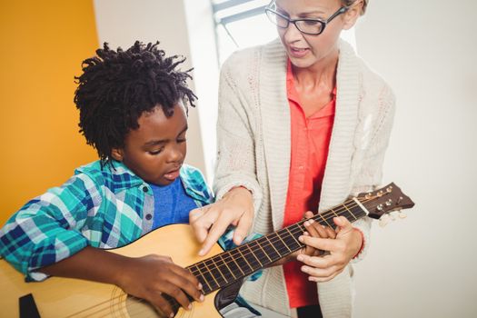 Boy learning how to play the guitar
