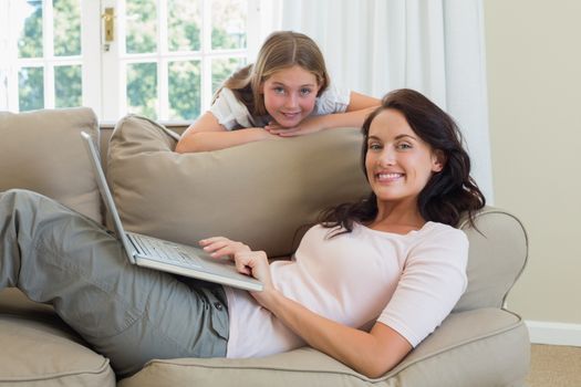 Mother and daughter with laptop in living room