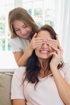 Girl covering eyes of mother
