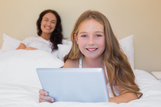 Girl using digital tablet in bedroom