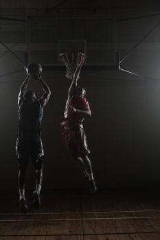 Basketball player shooting a basketball with a defender