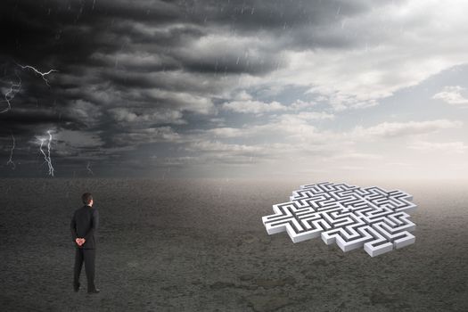 Composite image of a businessman who is looking a labyrinth 