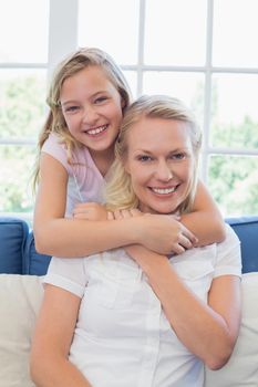 Cute girl embracing mother from behind