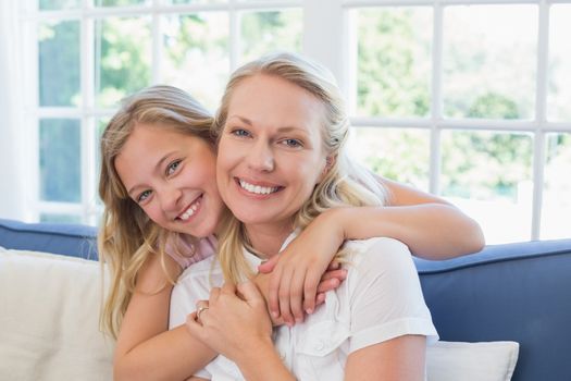 Loving girl embracing mother from behind