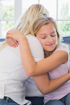Girl with eyes closed embracing mother