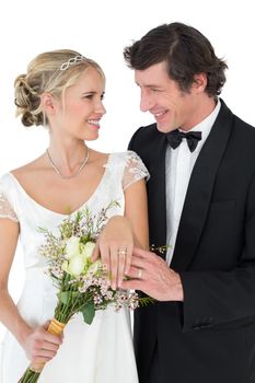 Bride and groom wearing wedding rings over white background