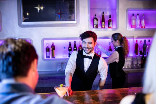 Waiter serving cocktail