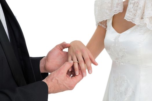 Loving groom and bride exchanging wedding ring