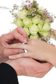 Cropped image of groom and bride exchanging ring