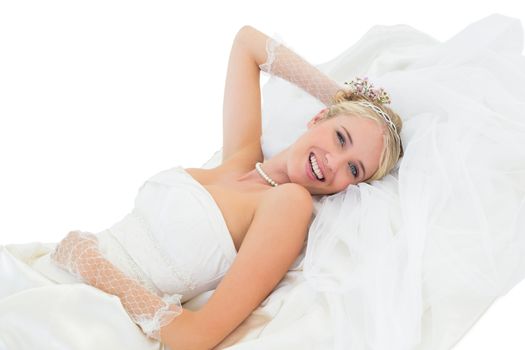 Happy sensuous bride lying against white background