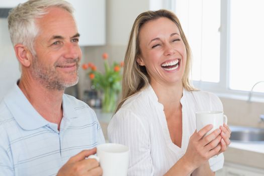 Laughing couple having coffee together
