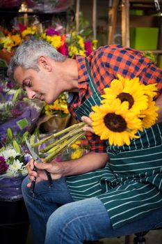 Male florist trimming stems of flowers at flower shop