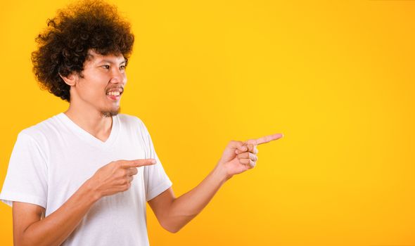 Asian Portrait happy young man curly hair pointing fingers away 
