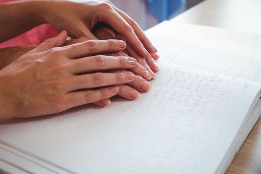 Nurse helping senior woman with braille