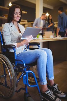 Disabled businesswoman smiling while using digital tablet
