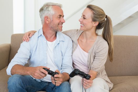 Happy couple having fun on the couch playing video games