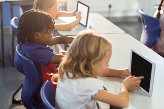Schoolchildren using digital tablets 