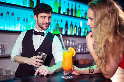 Handsome bartender flirting with young woman