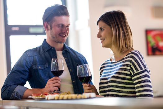 Couple holding wineglass at counter