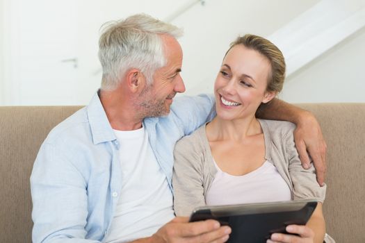 Happy couple using tablet pc together on the couch