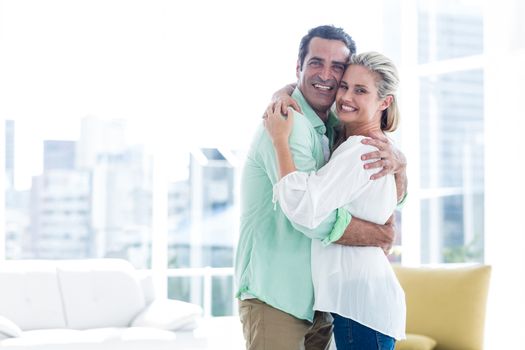 Mid adult smiling couple hugging at home