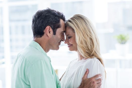 Mid adult couple embracing at home